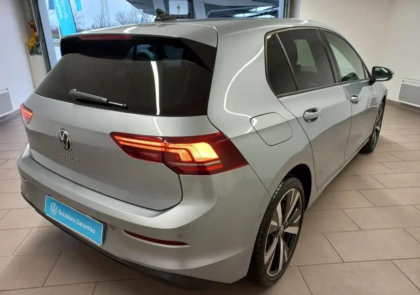 Vue 3/4 arrière droite d'une Volkswagen Golf 2025 argent Dolomite avec jantes alliage léger 18 pouces Catania.