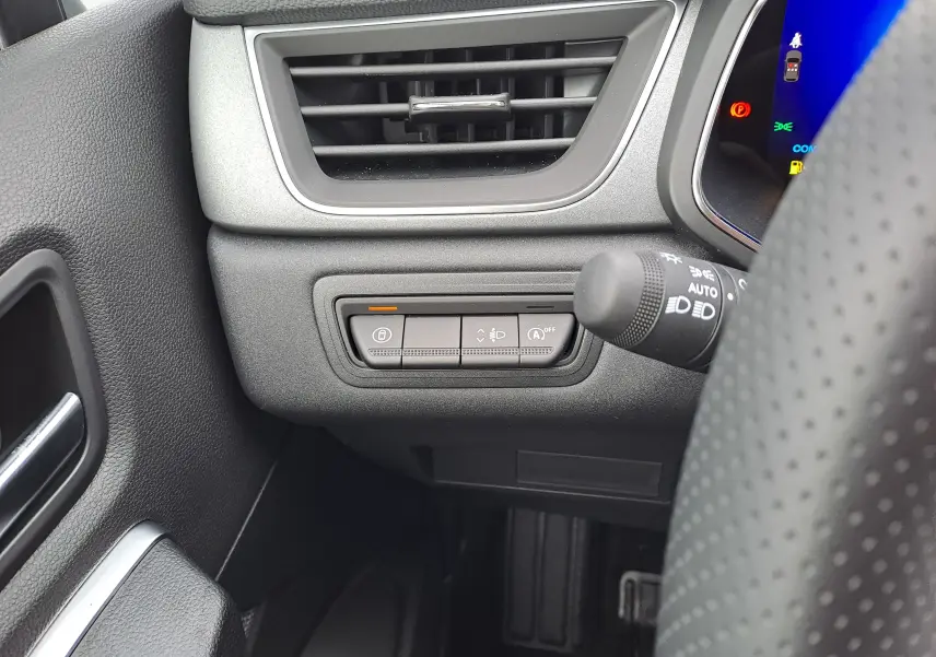 Gros plan sur les commandes à gauche du volant dans l’habitacle noir du Renault Symbioz bleu Mercure 2025.