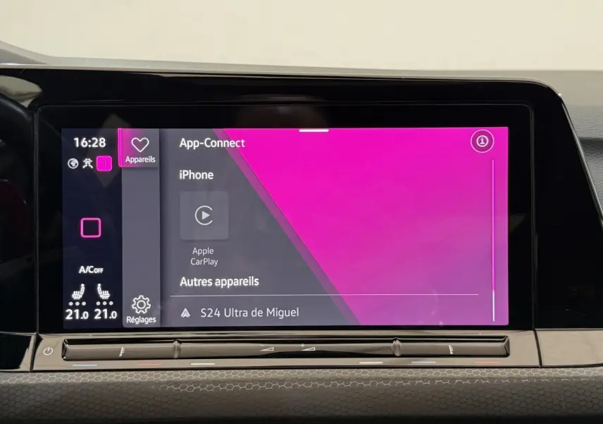 Écran tactile central intérieur affichant Apple CarPlay dans une Volkswagen Golf gris foncé, vue de face.