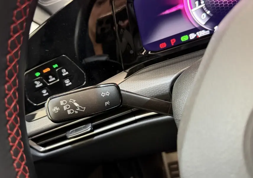 Gros plan sur la commande de clignotants et tableau de bord numérique d’une Volkswagen Golf GTI Clubsport gris foncé, vue côté gauche.