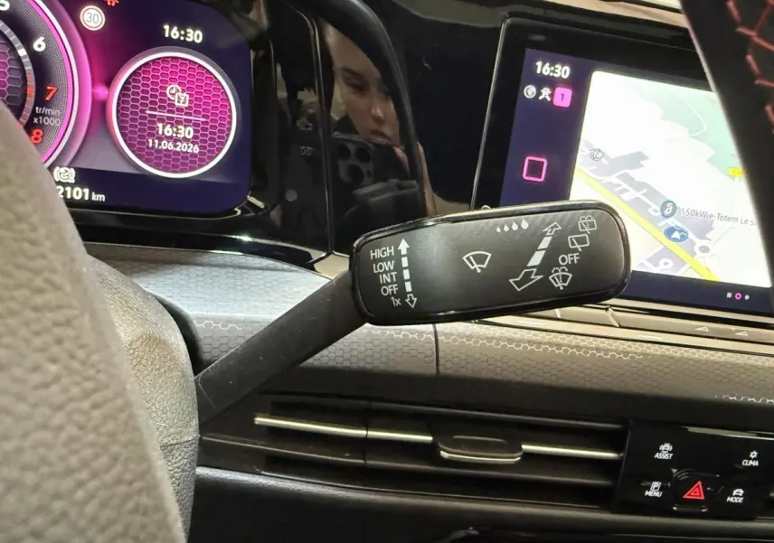 Vue intérieure du tableau de bord de la Volkswagen Golf GTI ClubSport 2022, avec affichage numérique violet et écran tactile de navigation.