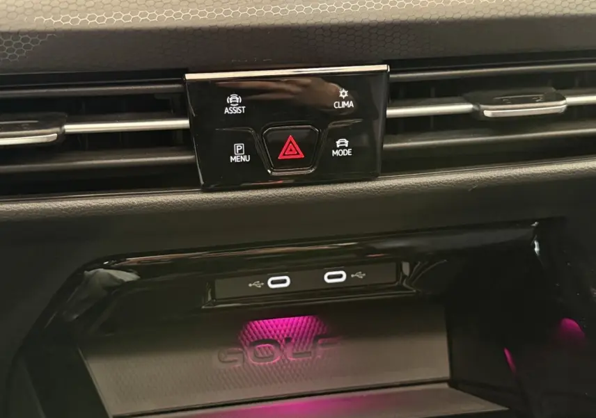 Détail du tableau de bord noir de la Volkswagen Golf GTI Clubsport 2022 avec éclairage d’ambiance violet et ports USB-C.