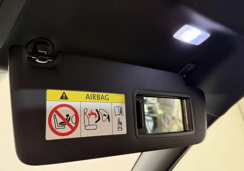 Détail du pare-soleil côté conducteur avec miroir et avertissement airbag dans une Volkswagen Golf gris foncé.