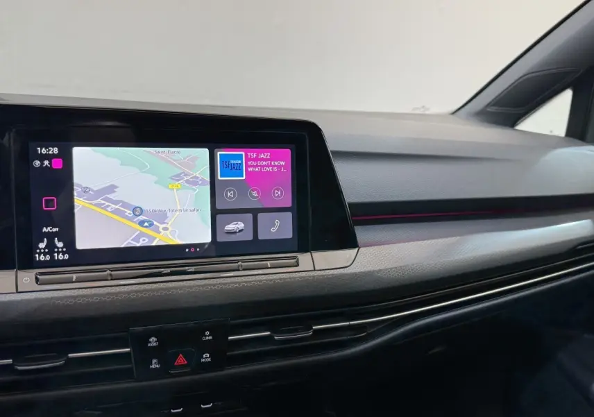 Tableau de bord de Volkswagen Golf GTI Clubsport 2022 avec écran tactile et ambiance lumineuse violette intégrée.