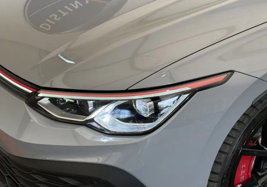 Gros plan sur le phare avant droit gris foncé de la Volkswagen Golf GTI Clubsport avec étrier de frein rouge visible.