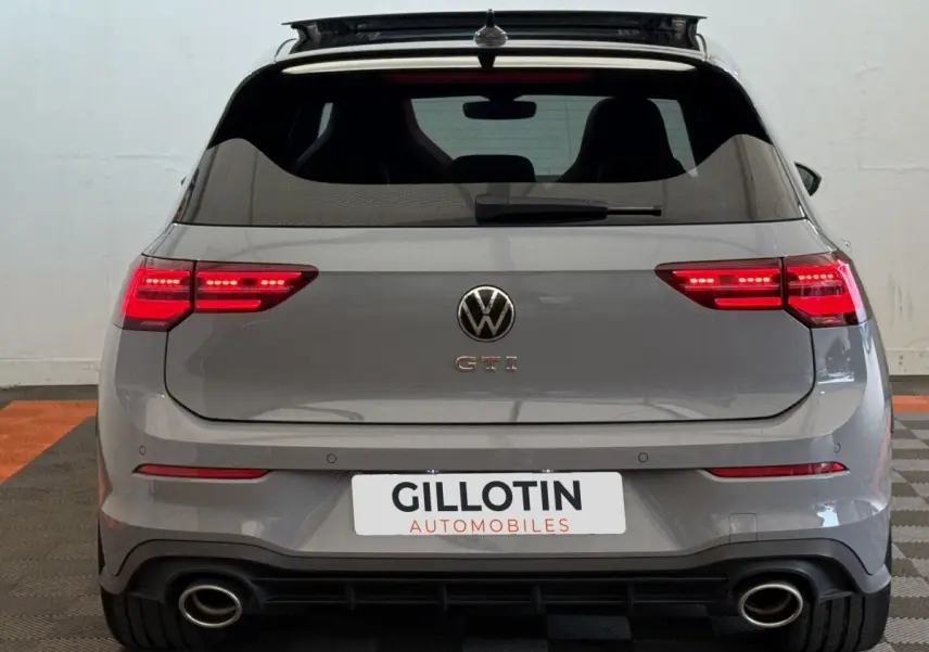 Vue arrière d'une Volkswagen Golf GTI Clubsport 2.0 TSI gris foncé avec feux LED allumés et double sortie d'échappement.