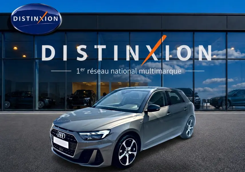 Audi A1 Sportback 30 TFSI gris chronos vue 3/4 avant droit avec jantes alu et toit noir devant showroom Distinxion.