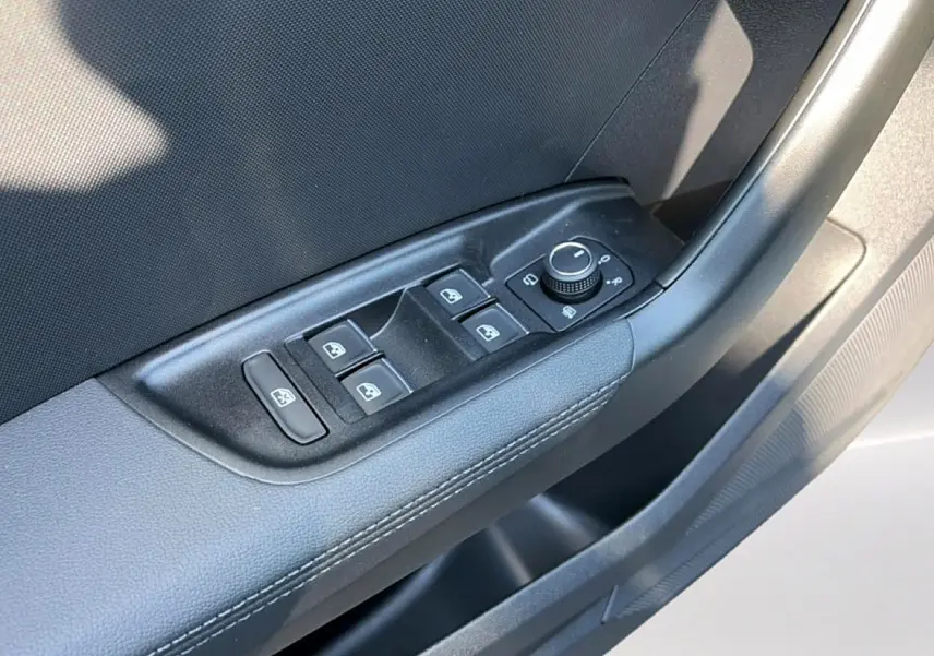 Détail des commandes des vitres et rétroviseurs sur la porte avant gauche de l'Audi A1 Sportback gris chronos.