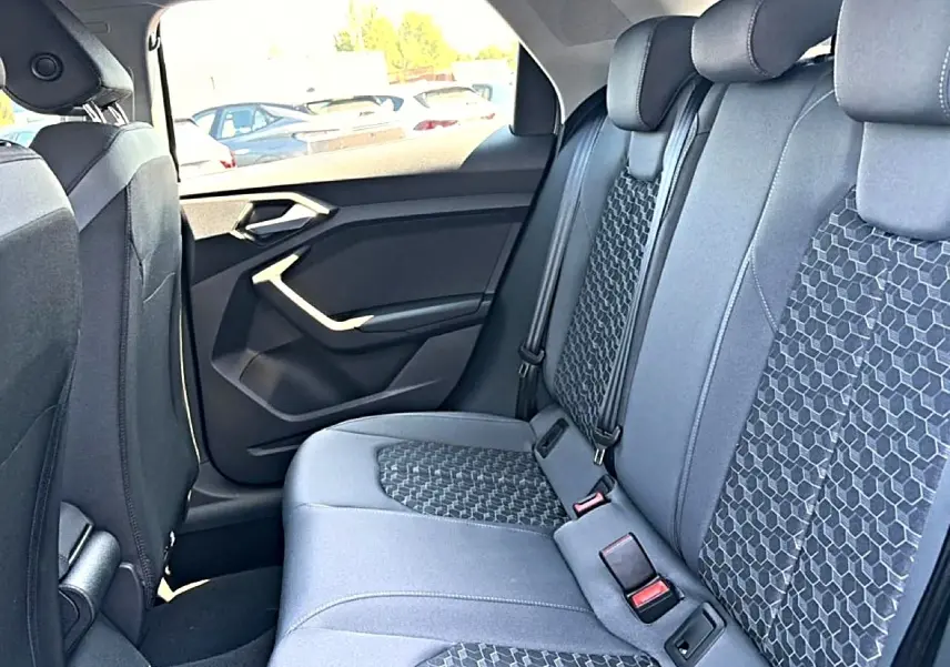 Vue intérieure arrière côté droit de l'Audi A1 Sportback 2026 avec sièges tissu gris à motifs hexagonaux.