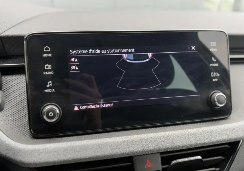 Écran tactile central du Skoda Scala 2024 affichant le système d'aide au stationnement avec commandes autour.