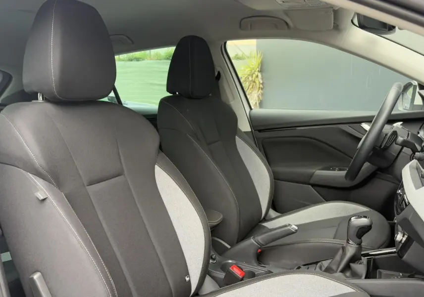 Intérieur de la Skoda Scala 2024, vue côté droit sur sièges tissu bicolore gris et noir avec surpiqûres.
