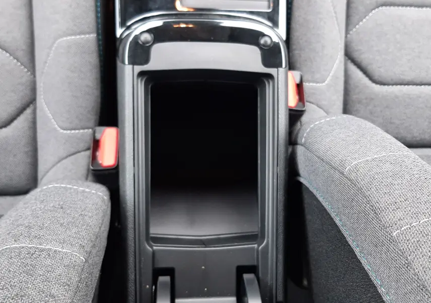 Vue plongeante sur la console centrale ouverte entre les sièges gris tissu du Citroën C4 Hybrid 136 e-DSC6 Plus 2024.