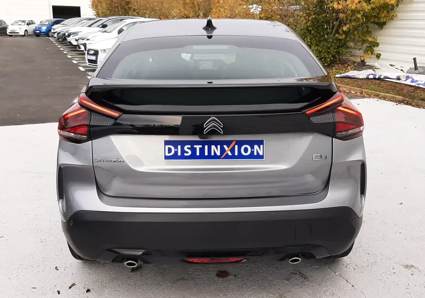 Vue arrière d'une Citroën C4 gris acier 2024 avec feux LED distinctifs et double sortie d'échappement.