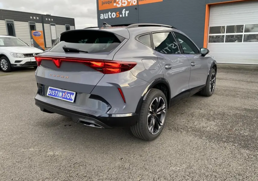 Vue 3/4 arrière droite d'un CUPRA Formentor gris Graphène avec jantes noires et feux arrière LED allumés.