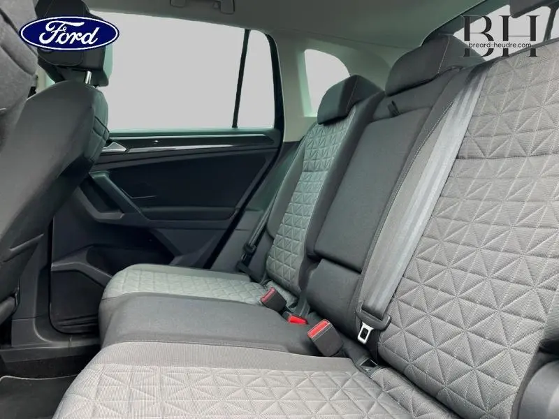 Vue latérale intérieure des sièges arrière en tissu gris à motifs géométriques d'un Volkswagen Tiguan 2022.