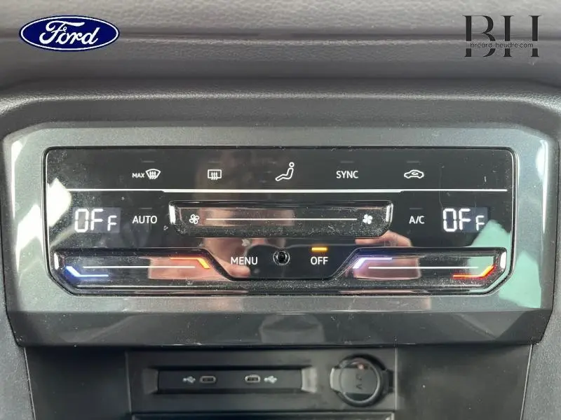 Panneau de commande de climatisation tactile noir avec affichage digital dans un Volkswagen Tiguan noir intense nacrée, vue frontale.