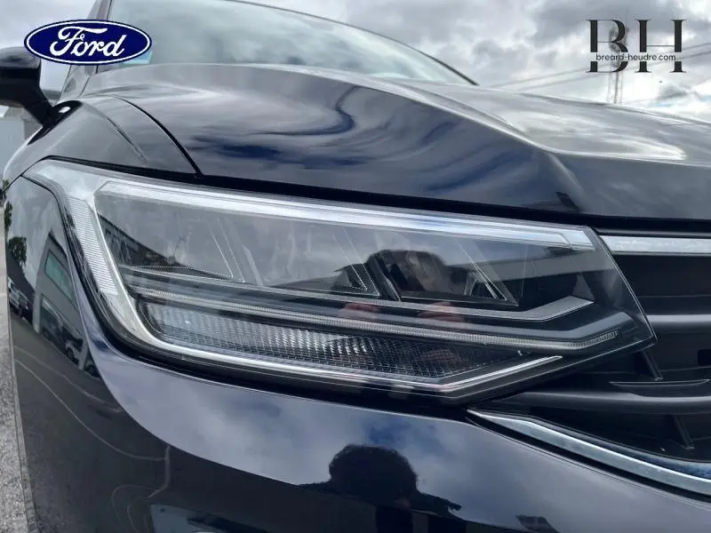 Gros plan sur le phare avant gauche du Volkswagen Tiguan noir intense nacrée, mettant en valeur son design LED moderne.