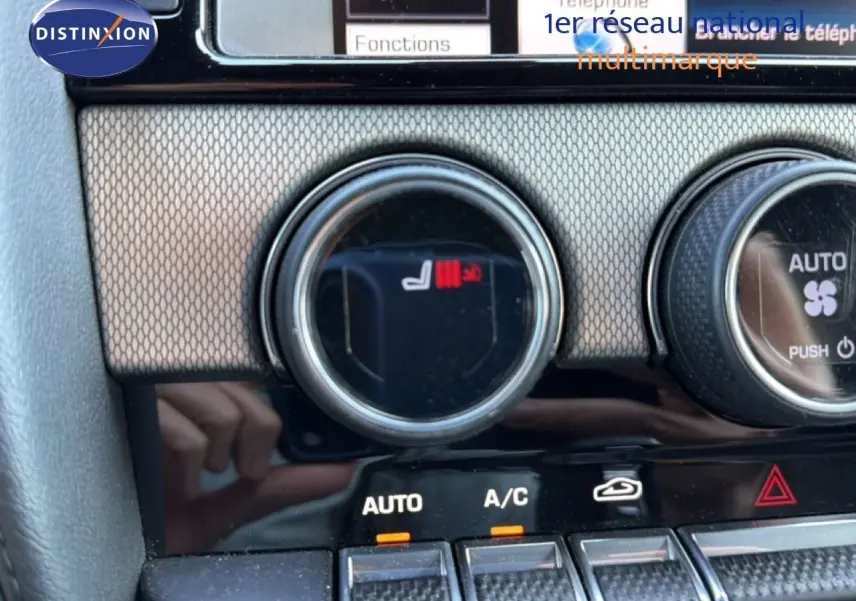 Gros plan sur la commande de chauffage de siège et climatisation dans l'habitacle de la Jaguar F-TYPE gris 2013.