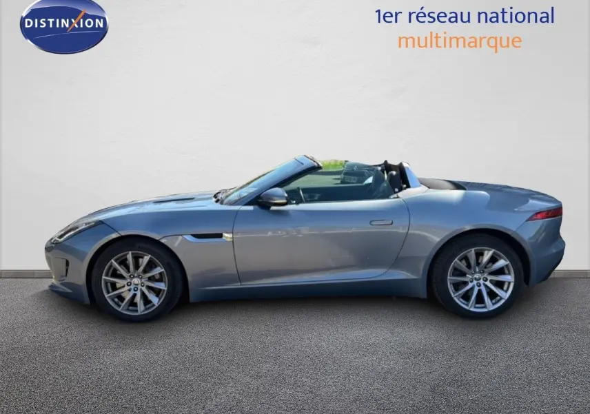 Jaguar F-TYPE gris vue de profil côté gauche, cabriolet avec jantes alliage et lignes fluides.