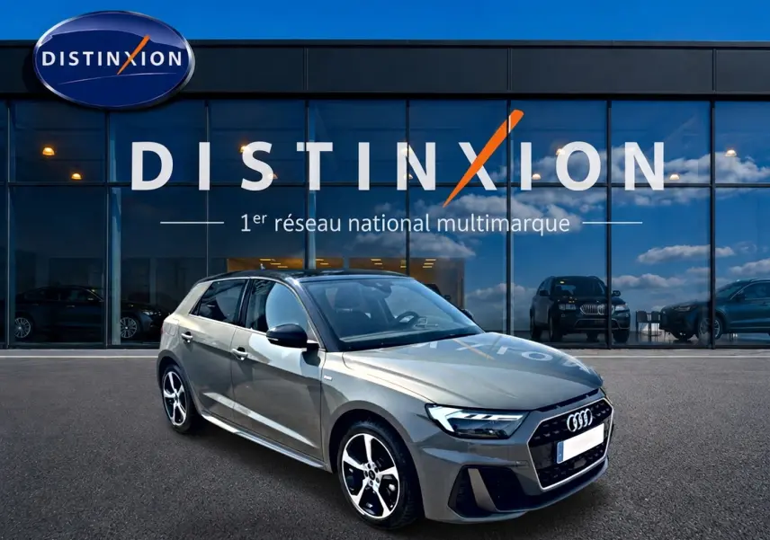 Audi A1 Sportback gris chronos vue 3/4 avant droit avec jantes alu et toit noir devant showroom Distinxion.