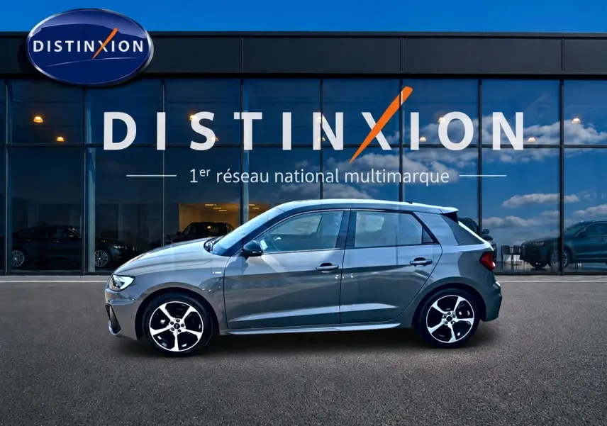 Audi A1 Sportback gris chronos vue de profil côté gauche avec jantes alu et toit noir devant showroom Distinxion.
