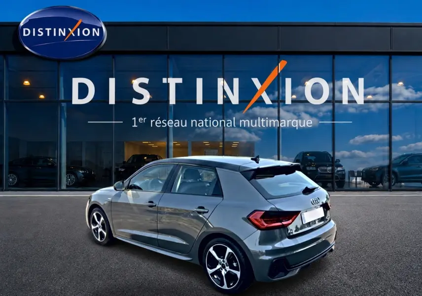Audi A1 Sportback gris chronos vue 3/4 arrière droit, avec jantes alu et becquet noir distinctif.
