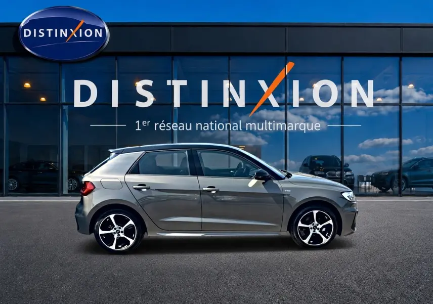 Audi A1 Sportback gris chronos vue de profil côté gauche, avec jantes alliage et toit noir devant showroom Distinxion.