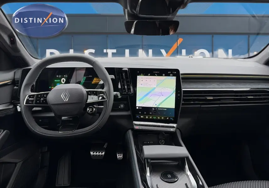 Vue intérieure frontale du tableau de bord et volant noir du Renault Austral gris schiste avec écran tactile central et affichage numérique.