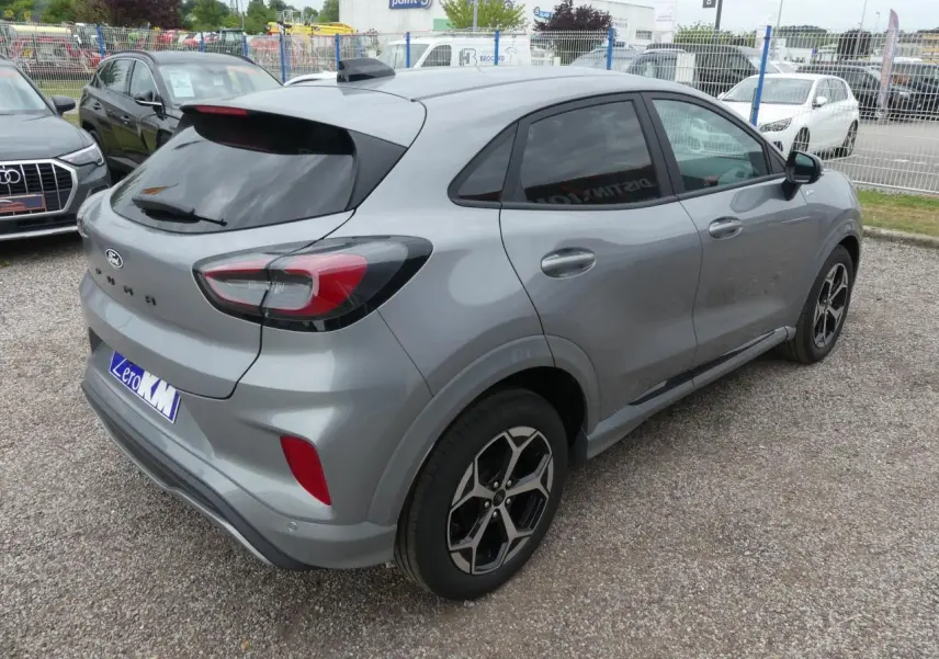 Vue 3/4 arrière droite d'un Ford Puma gris métallisé 2025 avec jantes alliage et vitres surteintées.