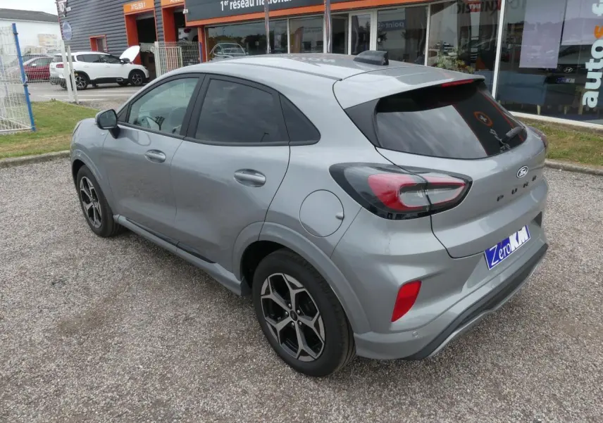 Vue 3/4 arrière droite d'un Ford Puma gris métallisé 2025 avec jantes alliage et vitres arrière surteintées.