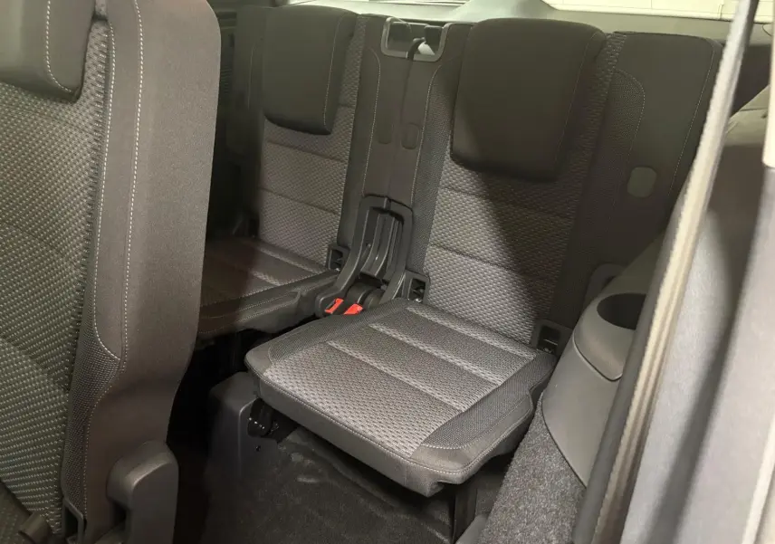 Vue intérieure sur la troisième rangée de sièges en tissu gris foncé du Volkswagen Touran 2025, version 7 places.