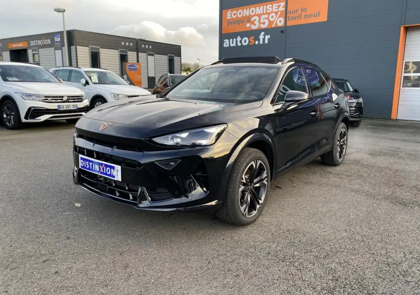 CUPRA Formentor noir Midnight en 3/4 avant droit, jantes sport bicolores, stationné devant un bâtiment commercial.