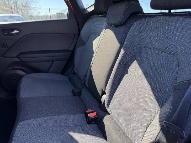 Vue intérieure sur les sièges arrière gris foncé du Renault Captur 2025, avec ceinture et appuie-têtes visibles.