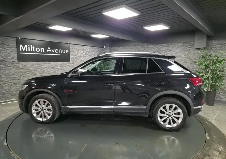 Volkswagen T-Roc noir vue de profil côté gauche dans un showroom avec jantes alliage 17 pouces.
