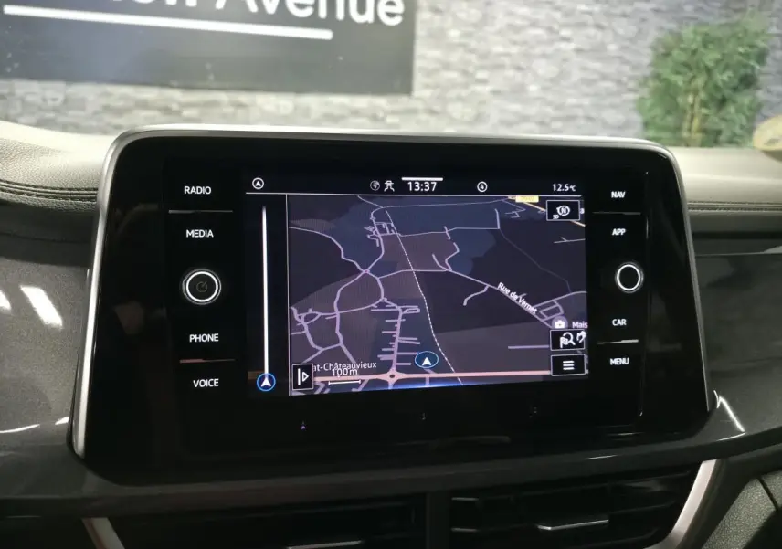 Écran tactile central du Volkswagen T-Roc noir 2022 affichant une carte de navigation, vue intérieure frontale.