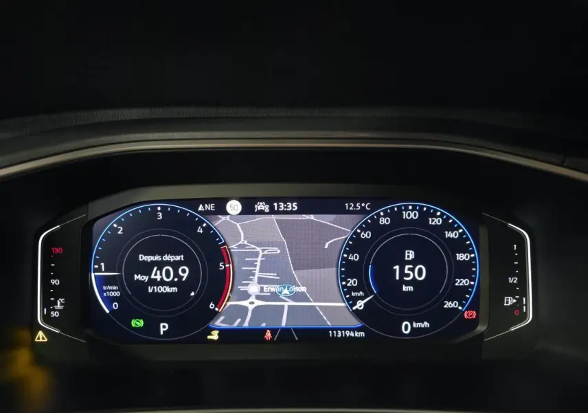 Affichage numérique du tableau de bord du Volkswagen T-Roc 2022, avec carte de navigation et compteurs lumineux bleus.