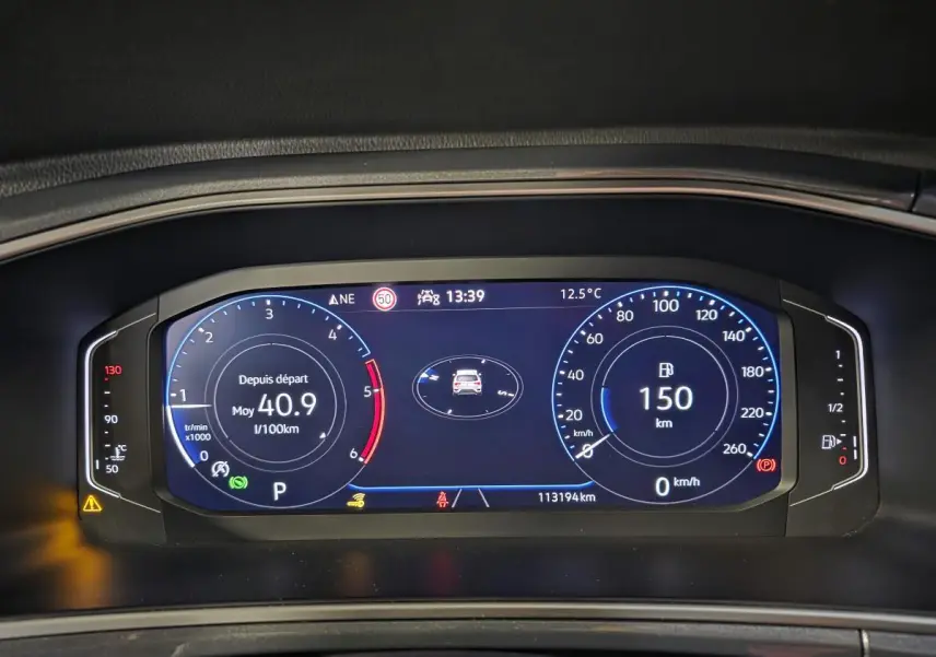 Vue rapprochée du combiné d'instruments digital du Volkswagen T-Roc 2022 affichant la consommation et la distance restante.