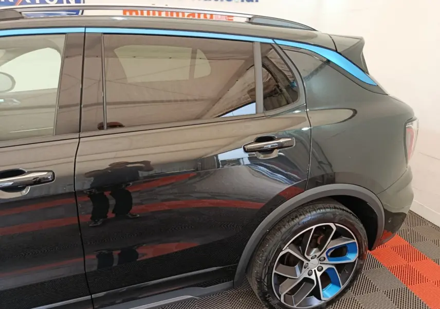Vue côté droit arrière du SUV Link & Co 01 noir avec jantes noires et bleues et bande bleue sur le toit.