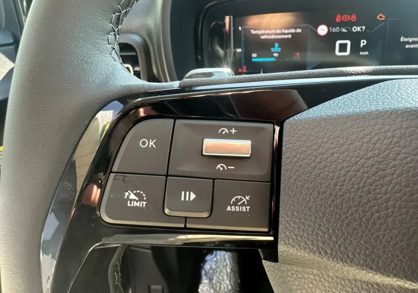 Gros plan sur les commandes multifonctions à gauche du volant cuir du Citroën Berlingo 2026, finition Urban Grey.