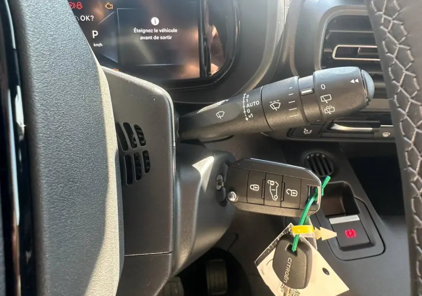 Vue rapprochée de la colonne de direction du Citroën Berlingo 2026, avec clé insérée et commandes d’essuie-glace visibles.