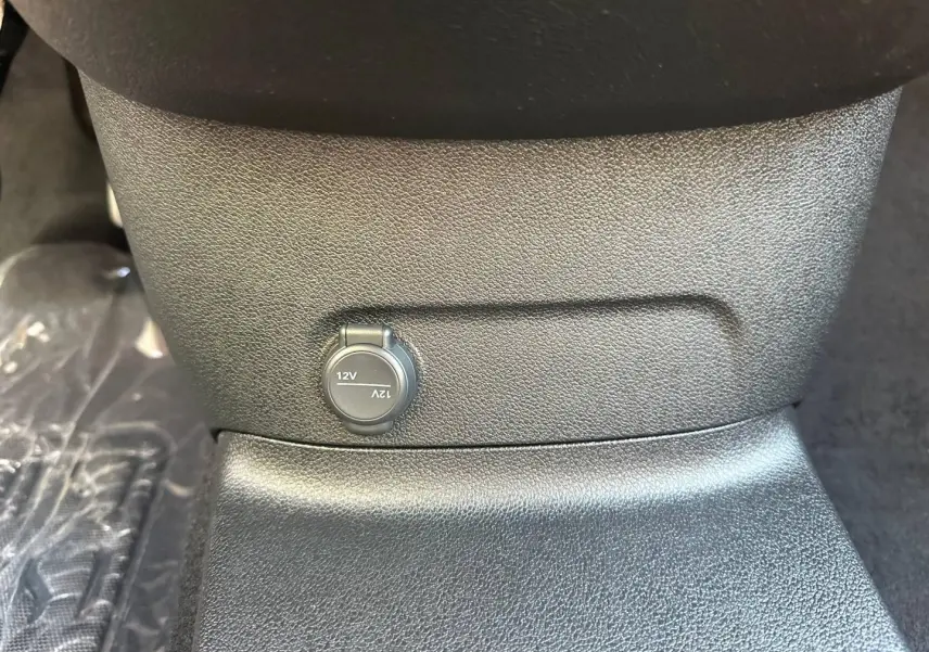 Prise 12V en gros plan sous la console centrale du CITROEN BERLINGO M 1.5 BlueHDi 130ch PLUS BVA8, intérieur noir.