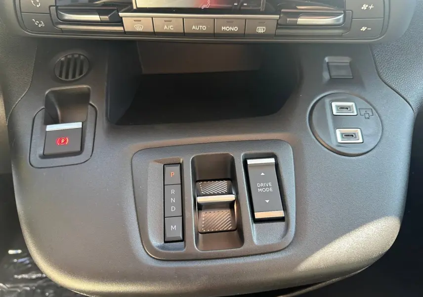 Gros plan sur la console centrale noire du Citroën Berlingo 2026 avec commandes boîte auto et ports USB visibles.