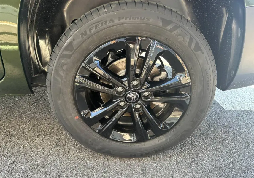 Gros plan sur la roue avant droite du Citroën Berlingo Sirkka Green avec jante alu noire brillante.