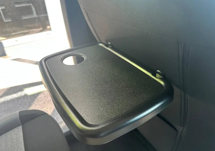 Tablette rabattable noire avec porte-gobelet, vue rapprochée sur le dossier d’un siège arrière du Citroën Berlingo 2026.