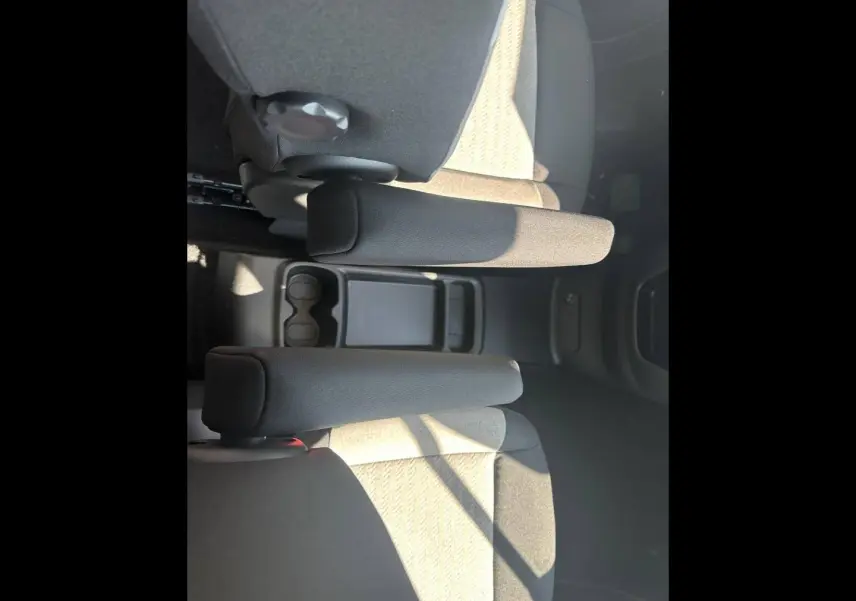 Vue plongeante sur les accoudoirs centraux et sièges arrière en tissu gris clair du Citroën Berlingo 2026.