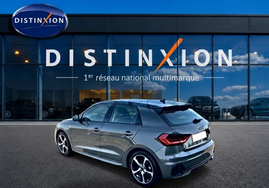 Audi A1 Sportback 30 TFSI S line gris chronos vue 3/4 arrière droit avec jantes alu et becquet noir.