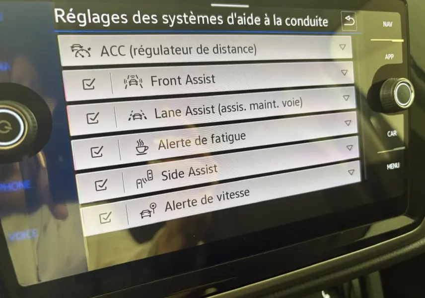Écran tactile du Volkswagen Touran 2025 affichant les réglages des aides à la conduite avec options activées.