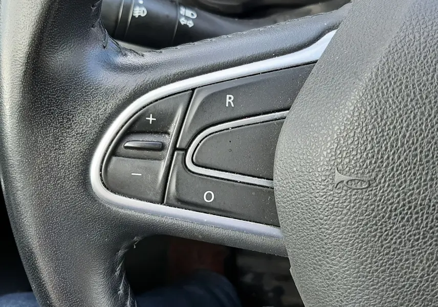 Gros plan sur les commandes à gauche du volant en cuir noir du Renault Kadjar gris, modèle 2018 diesel.