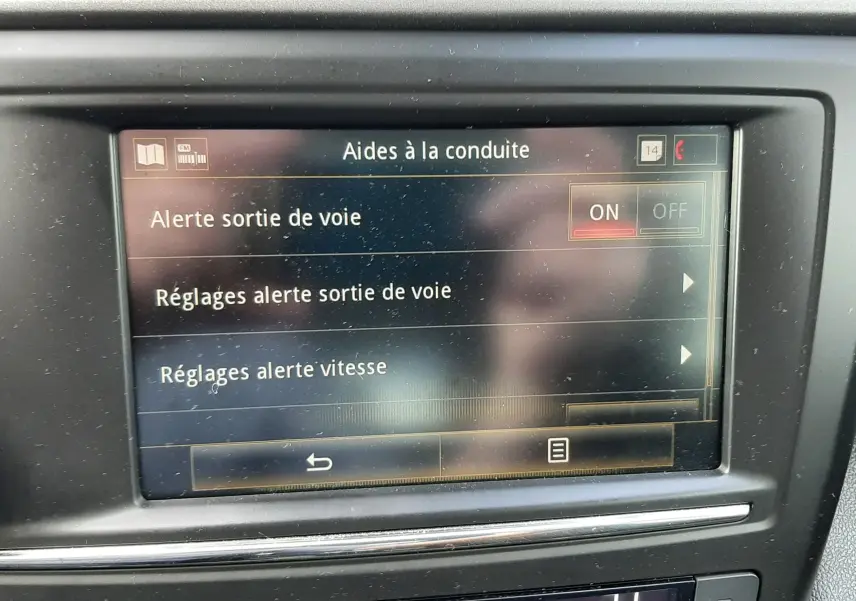 Écran tactile central du tableau de bord du Renault Kadjar gris, affichant les réglages d'aides à la conduite.