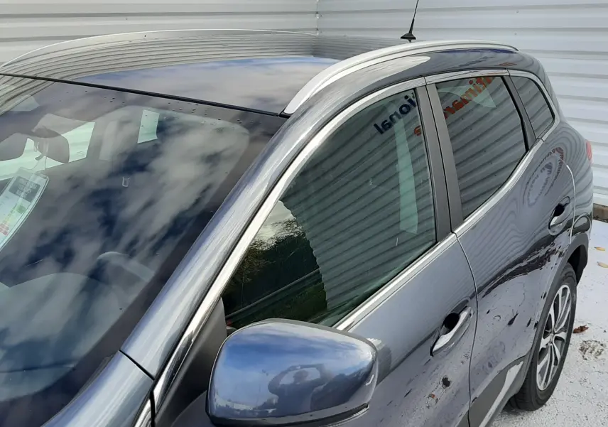 Vue de trois quarts avant droit d'un Renault Kadjar gris métallisé, mettant en valeur la carrosserie et les vitres teintées.